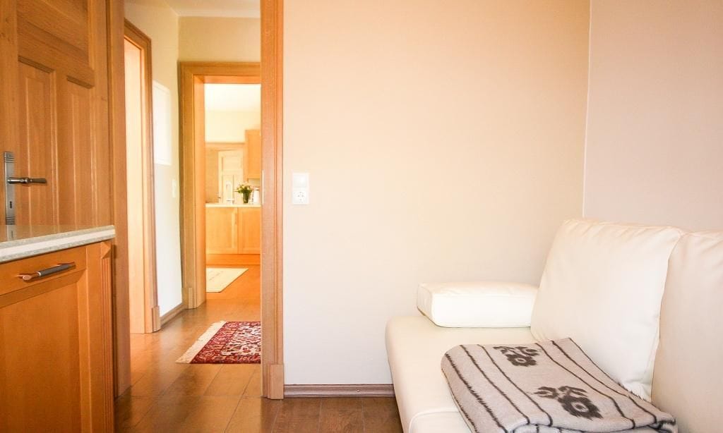 Wohnzimmer mit weißer Couch und Holzfußboden