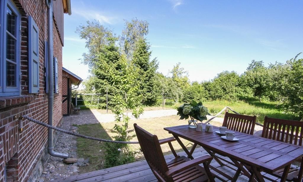 Terrasse mit Holztisch und Gartenblick