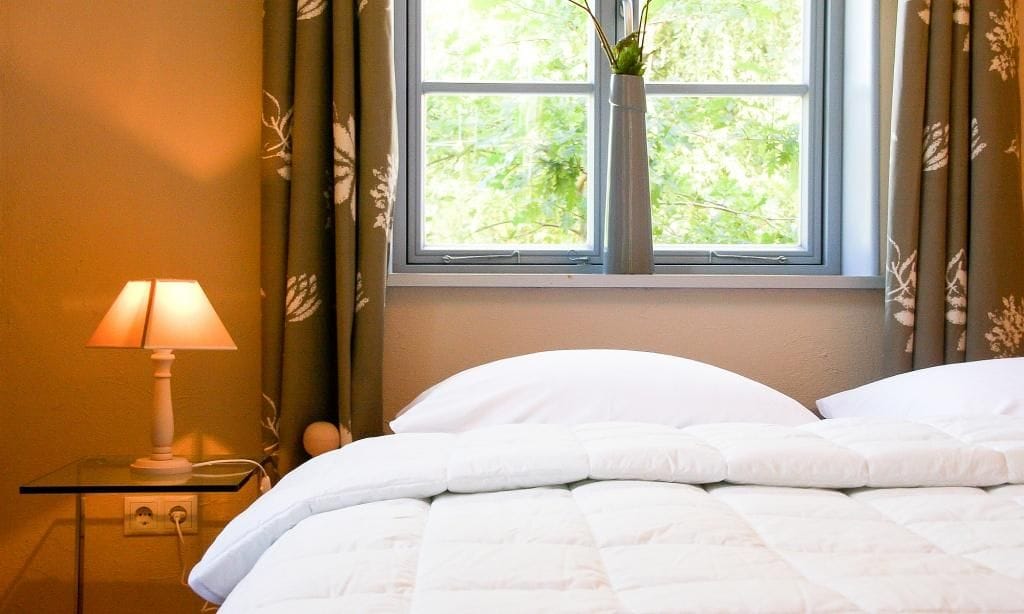 Schlafzimmer mit Bett und dekorativer Lampe