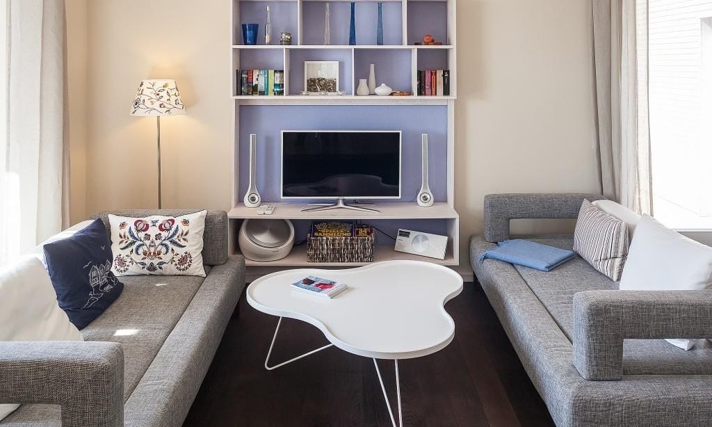 Helles Wohnzimmer mit zwei Sofas und Fernseher