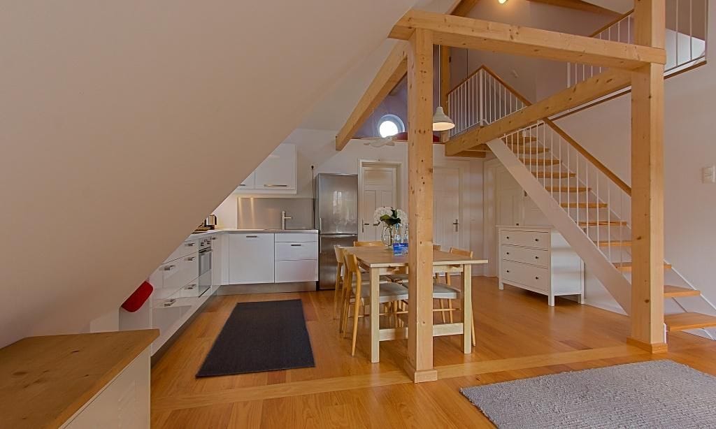 Helles Wohnzimmer mit modernem Esstisch und Holztreppe