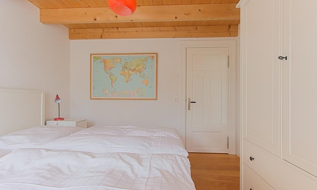 Schlafzimmer mit zwei Betten und Weltkarte