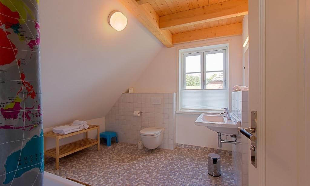 Helles Badezimmer mit Badewanne und Waschbecken.