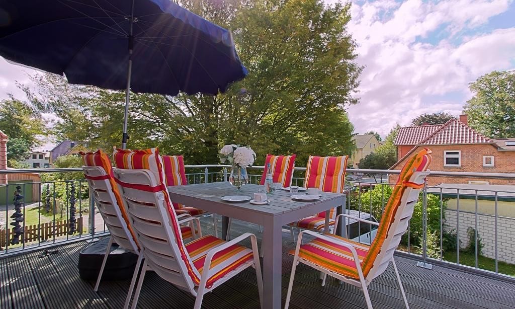 Gemütliche Terrasse mit Tisch und bunten Stühlen