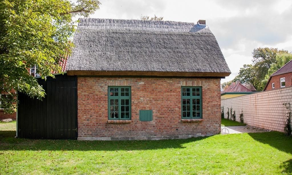Strohgedecktes Haus mit zwei Fenstern