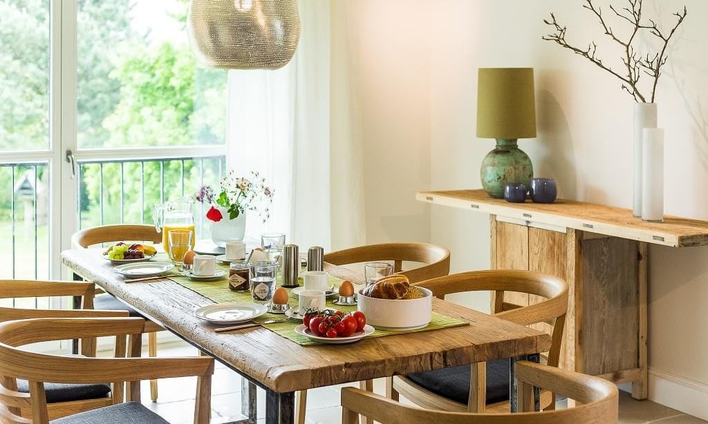 Moderne Küche mit Holztisch und Blick ins Freie