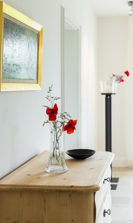 Innenansicht mit Holzkommode und Blumen