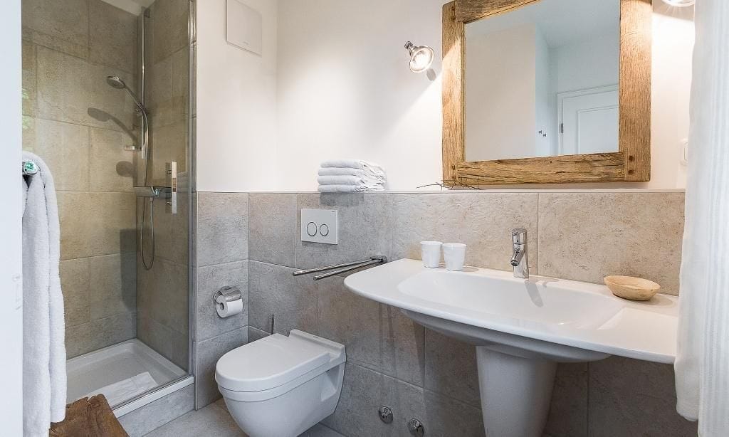 Modernes Badezimmer mit Dusche und Holzspiegel