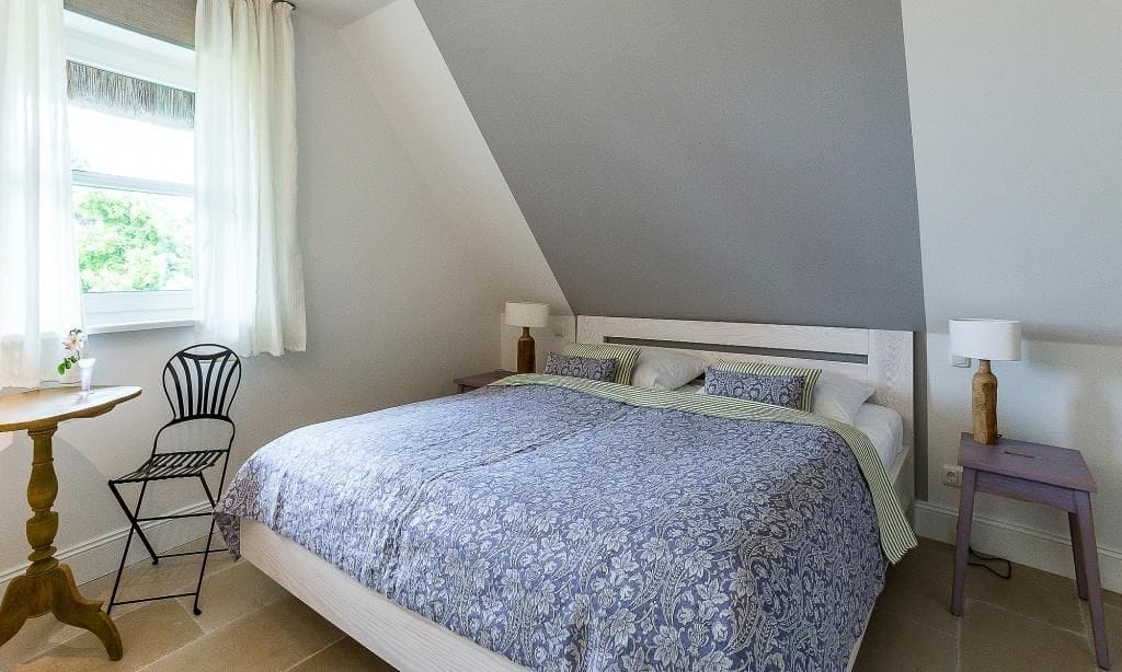 Schlafzimmer mit Doppelbett und Fensterblick