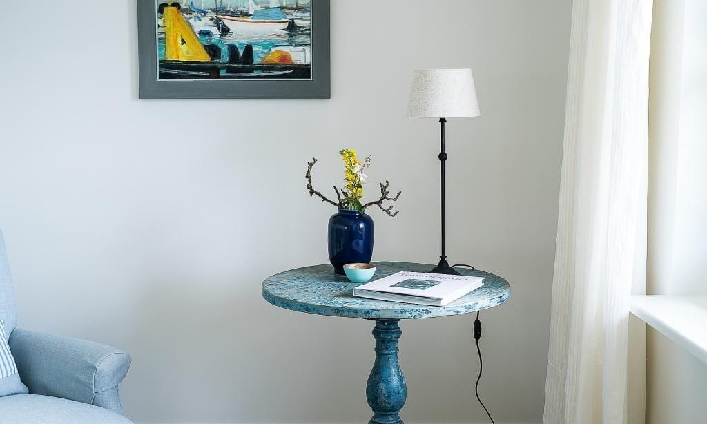 Wohnzimmer mit blauem Tisch und Lampe