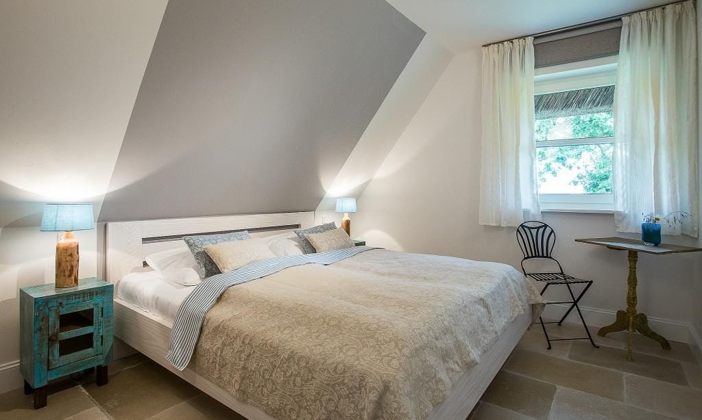 Gemütliches Schlafzimmer mit Doppelbett und Holzlampe