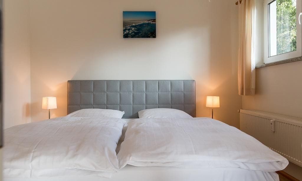 Schlafzimmer mit Doppelbett und sanfter Beleuchtung