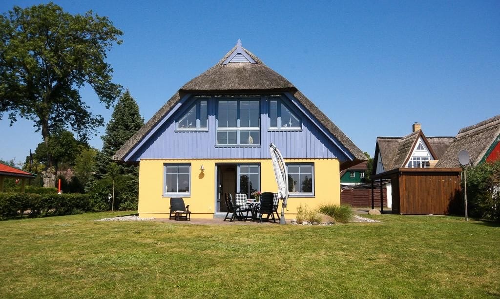 Außenansicht eines gelben Hauses mit Terrasse