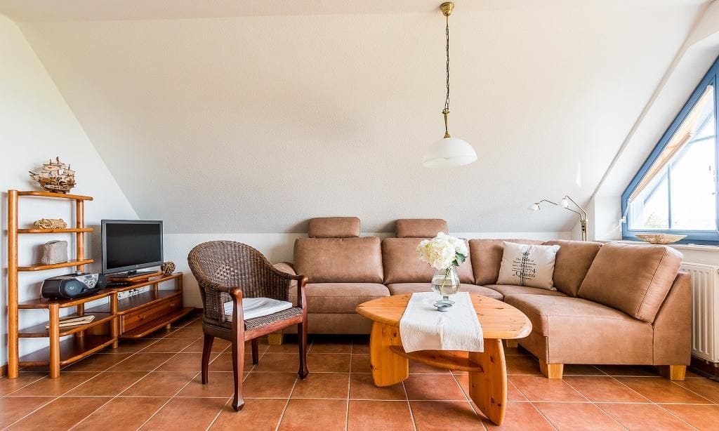 Gemütliches Wohnzimmer mit Sofa und Fernseher