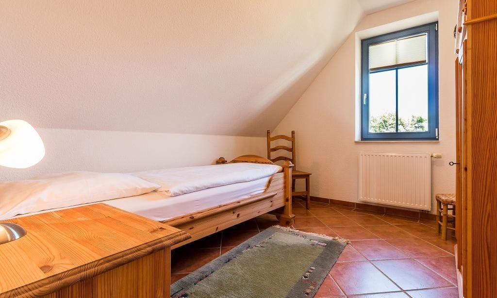 Schlafzimmer mit Einzelbett und Fensteraussicht