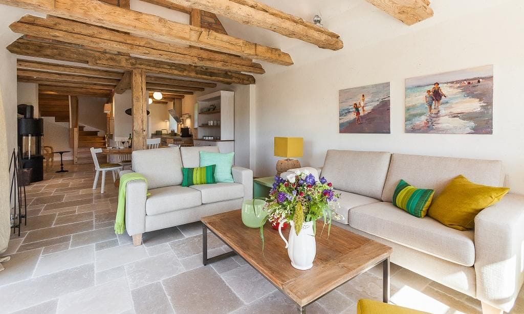 Gemütliches Wohnzimmer mit Sofas und Holzbalkendecke