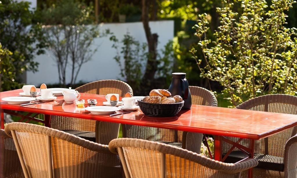 Terrasse mit großem Tisch und Frühstücksdekoration