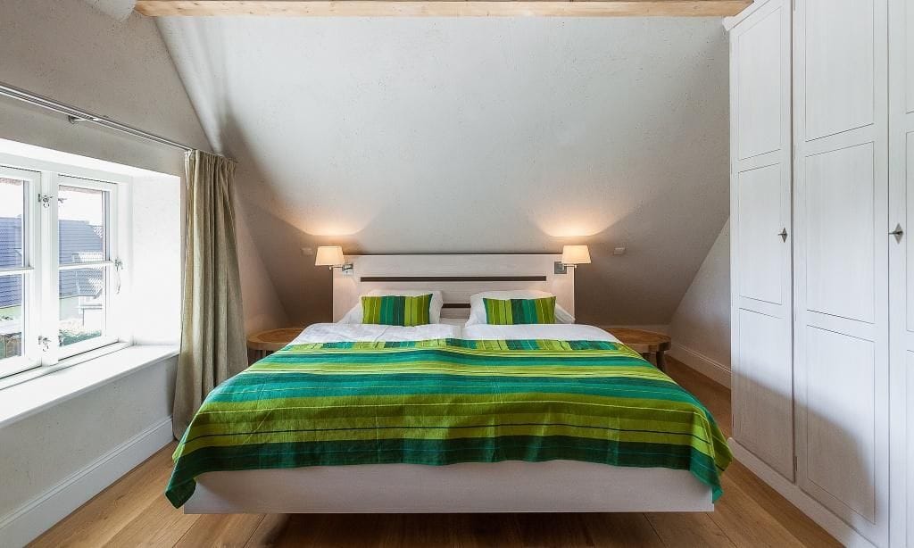 Schlafzimmer mit Doppelbett und Kommode.