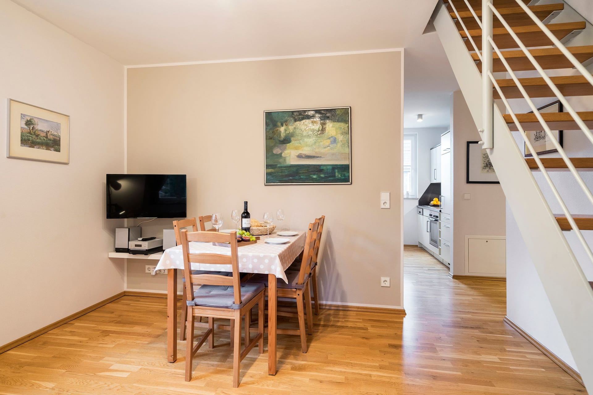 Essbereich mit Tisch, Stühlen und TV.
