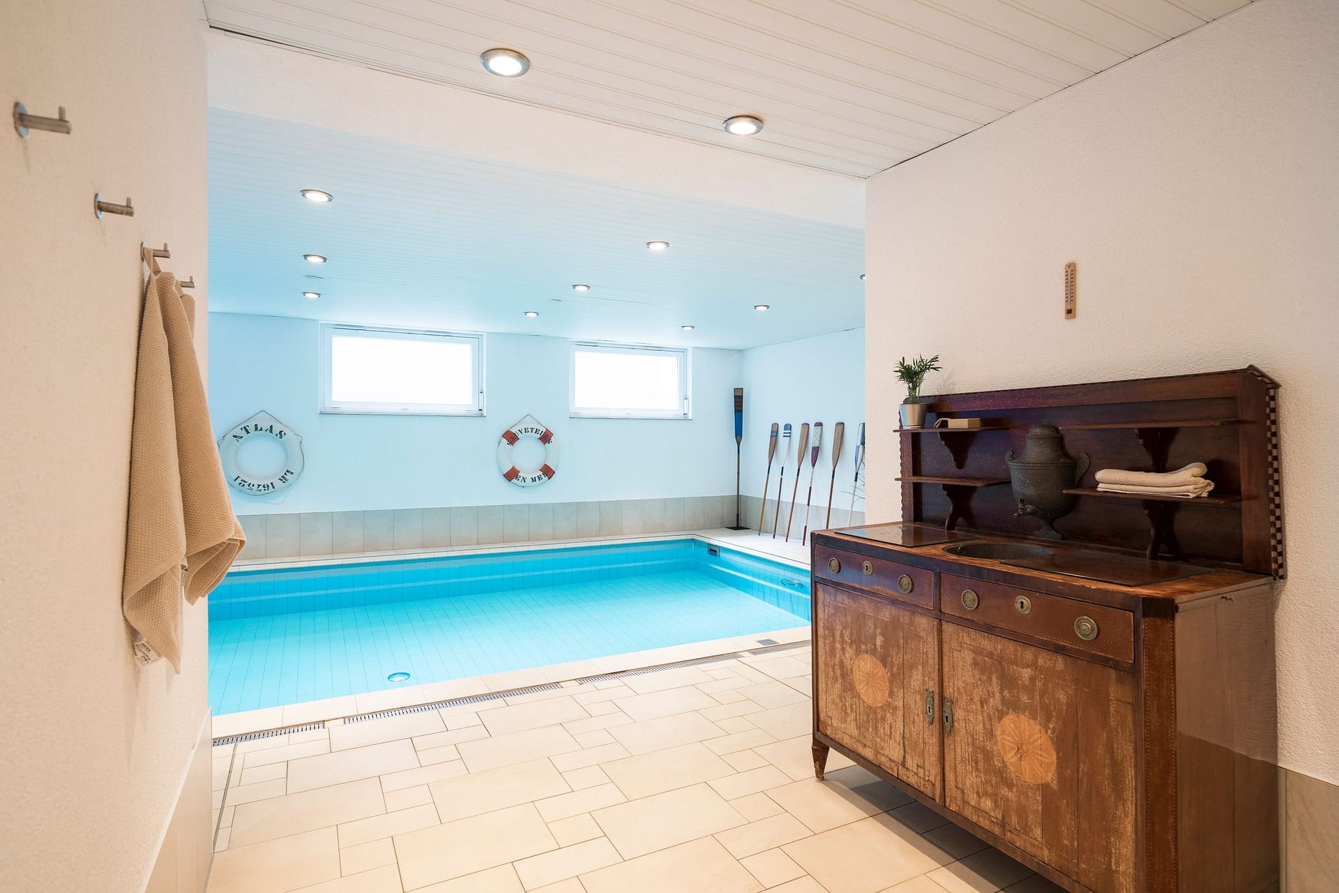 Innenansicht eines Schwimmbades mit Fenster und Holzschrank.