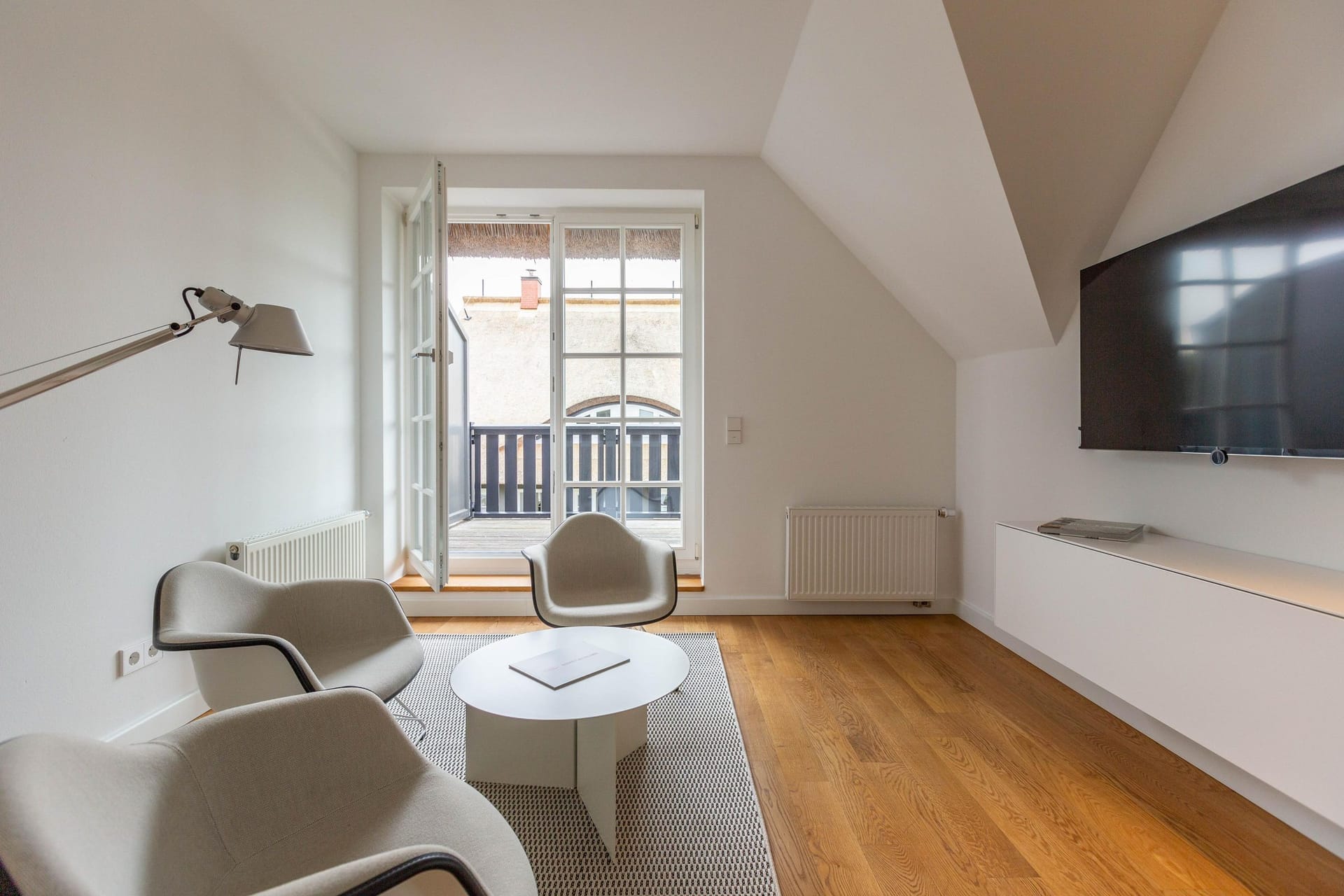 Heller Wohnraum mit Sessel und Balkon