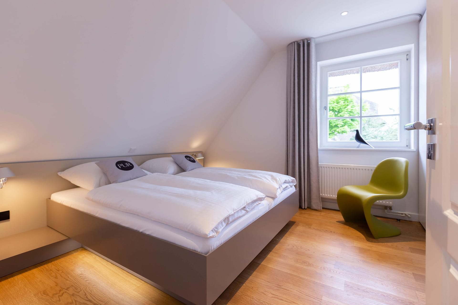 Helles Schlafzimmer mit Doppelbett und moderner Einrichtung