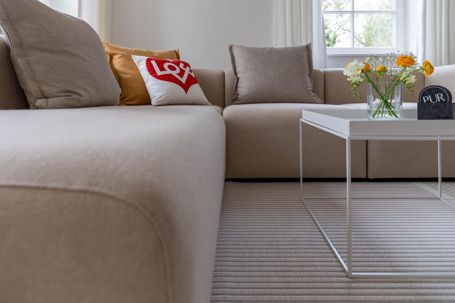 Gemütliches Wohnzimmer mit beigem Sofa und Tisch