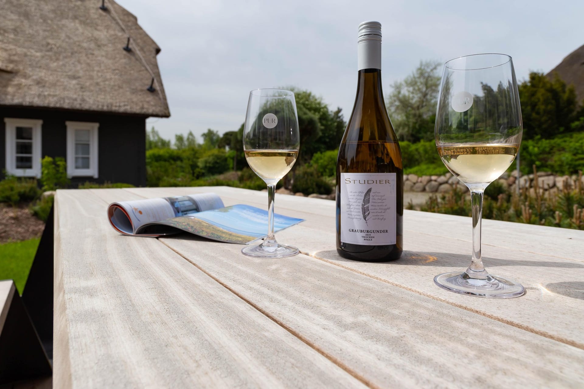 Terrasse mit Weingläsern und einer Weinflasche