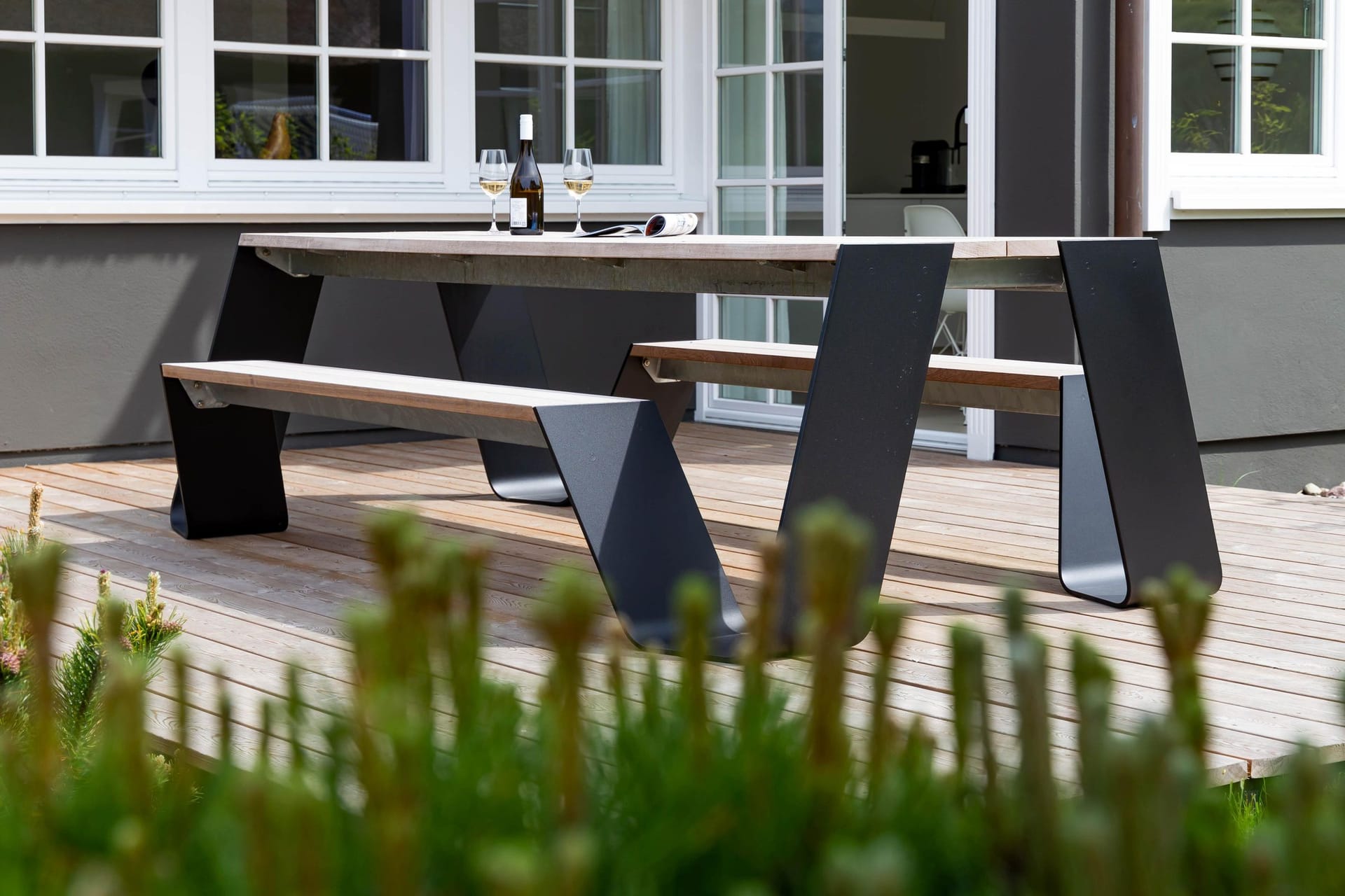 Terrasse mit Holztisch und modernen Bänken