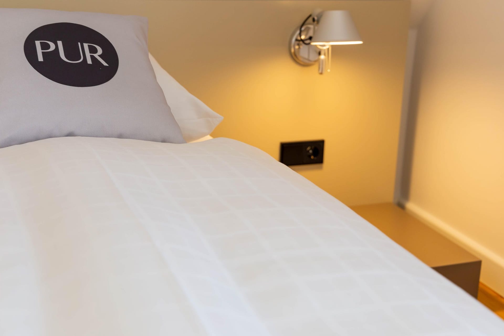 Schlafzimmer mit Bett und Wandlampe
