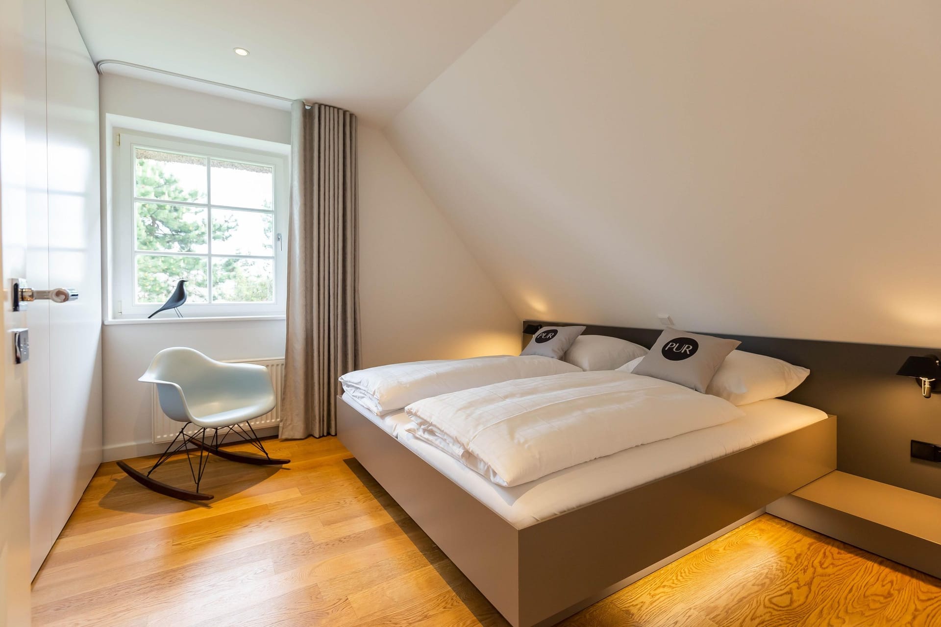 Schlafzimmer mit Doppelbett und Sessel
