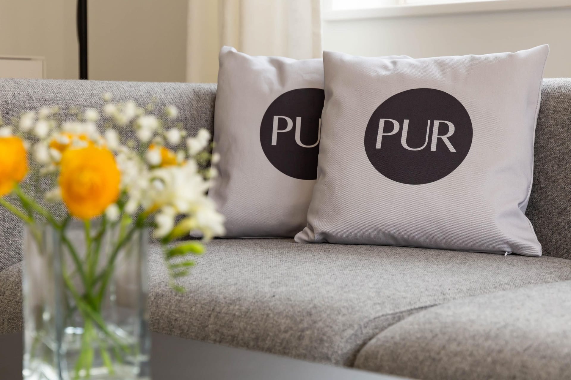 Modernes Wohnzimmer mit grauem Sofa und Kissen