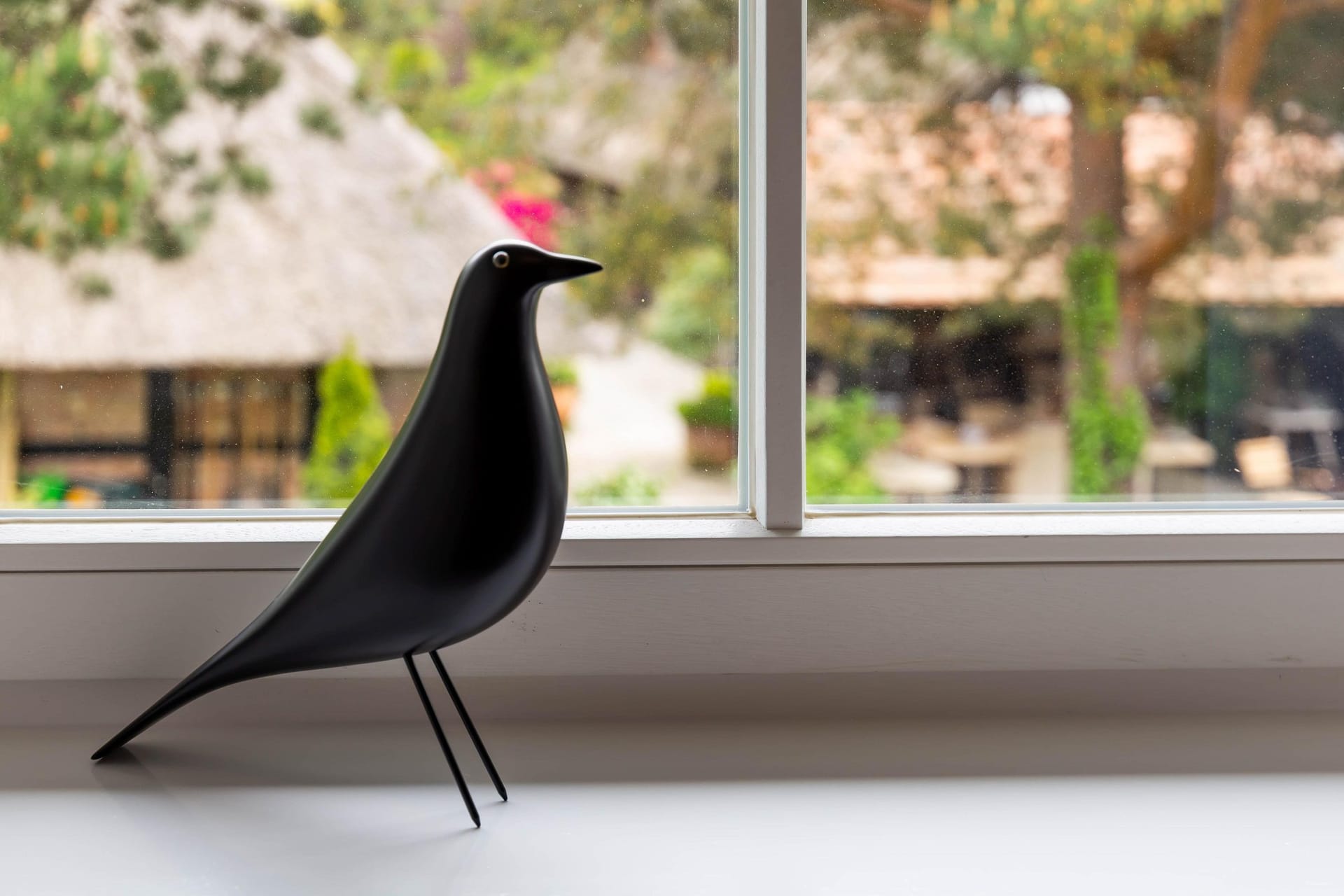 Dekorativer Vogel vor Gartenfenster