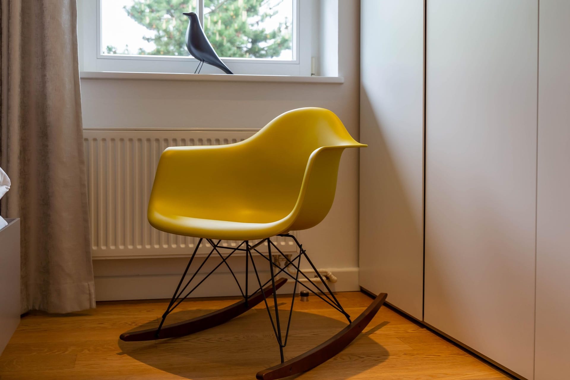 Schlafzimmer mit gelbem Schaubrockerstuhl