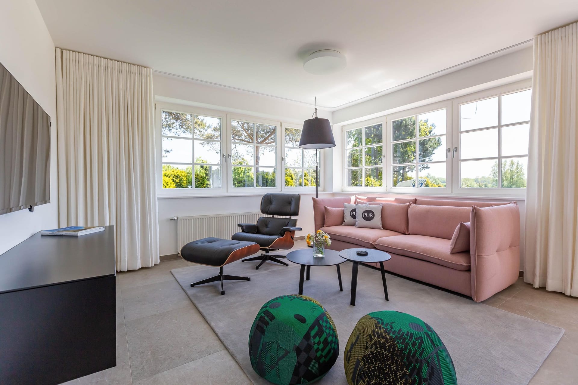 Helles Wohnzimmer mit Sofa und großen Fenstern