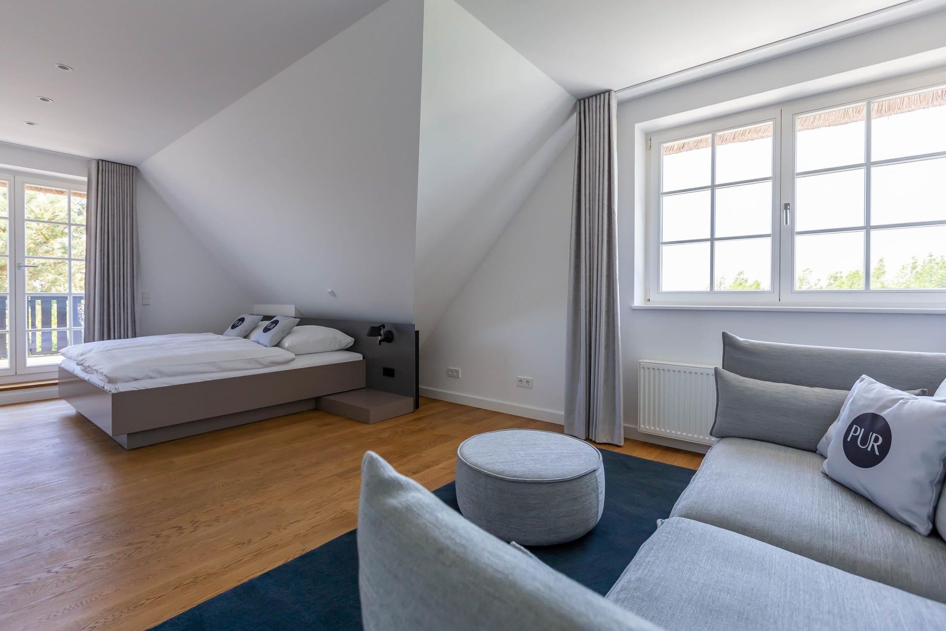 Schlafzimmer mit hellen Wänden und gemütlichem Sofa.