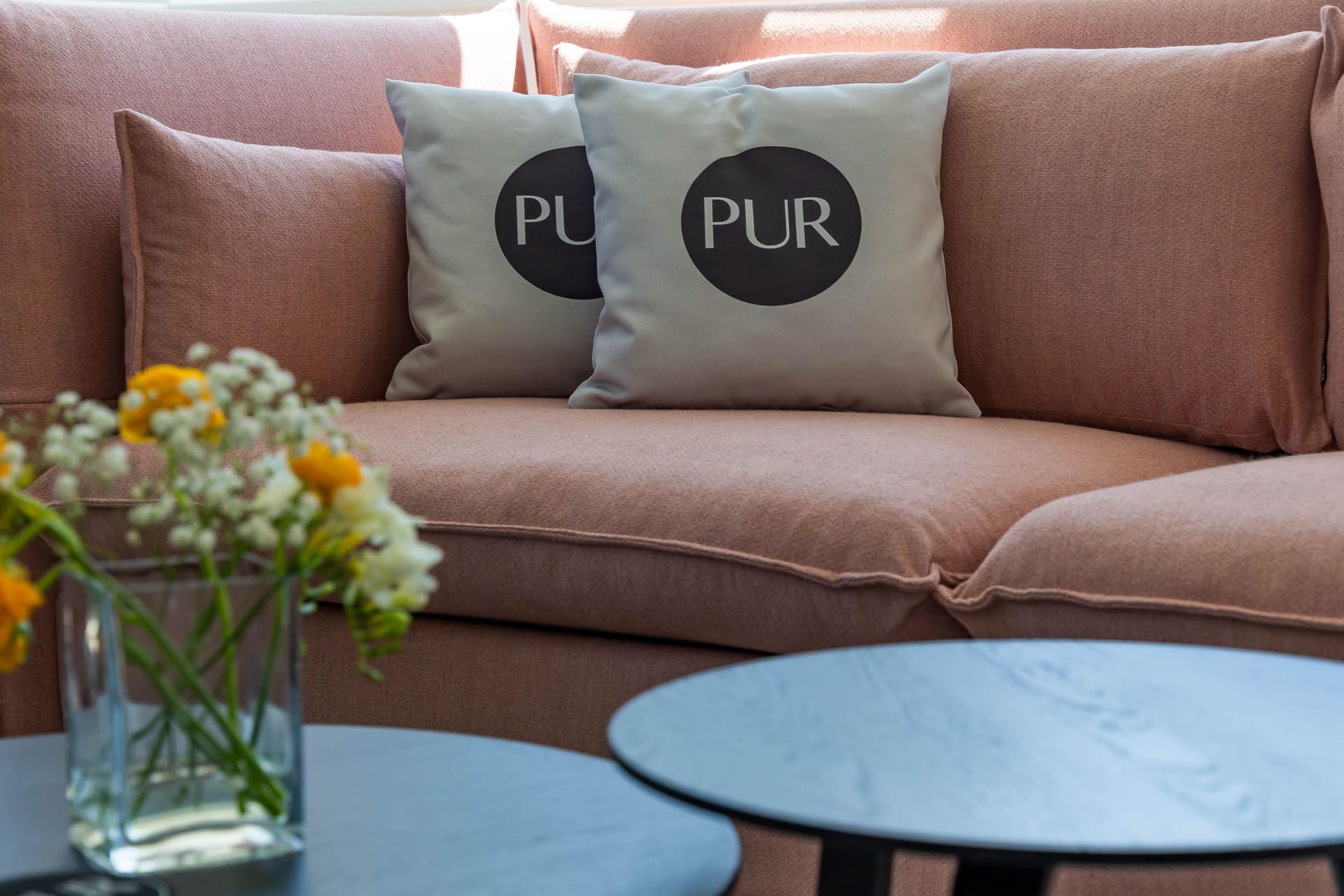 Gemütliches Wohnzimmer mit Couch und Kissen.
