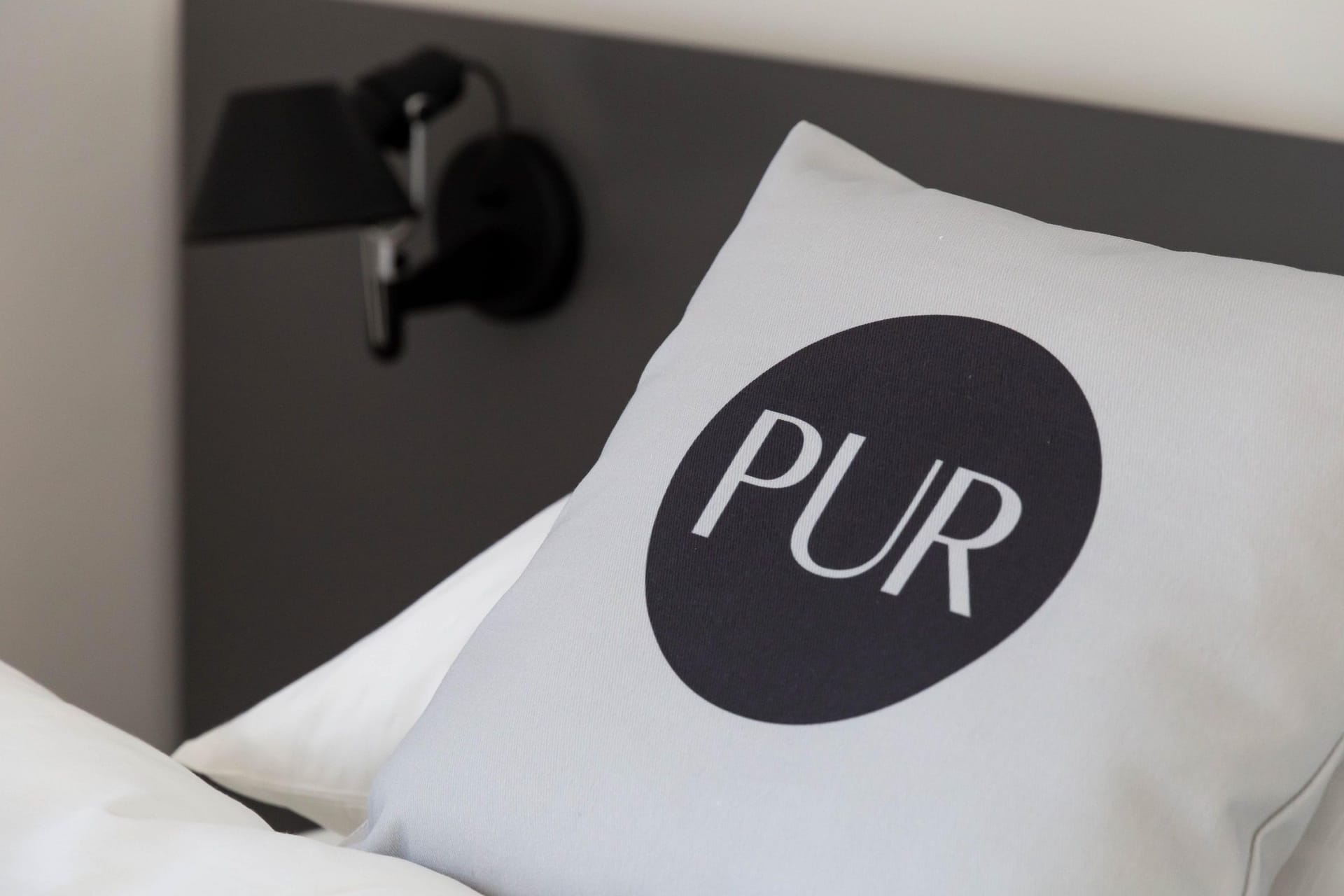 Schlafzimmer mit Kissen und moderner Lampe