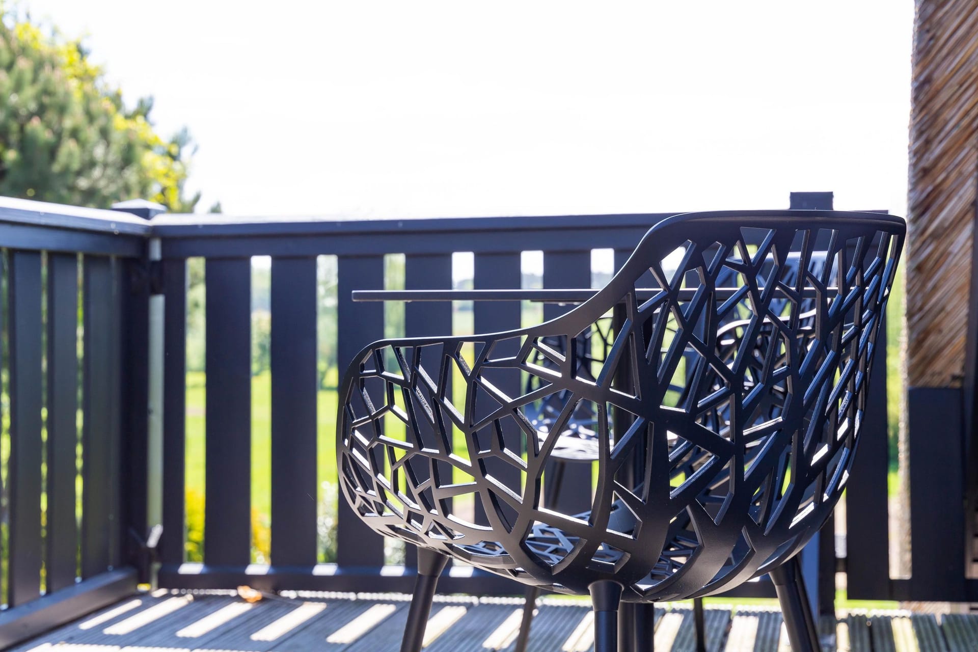 Moderne Terrasse mit Gartenstuhl und Blick ins Grüne