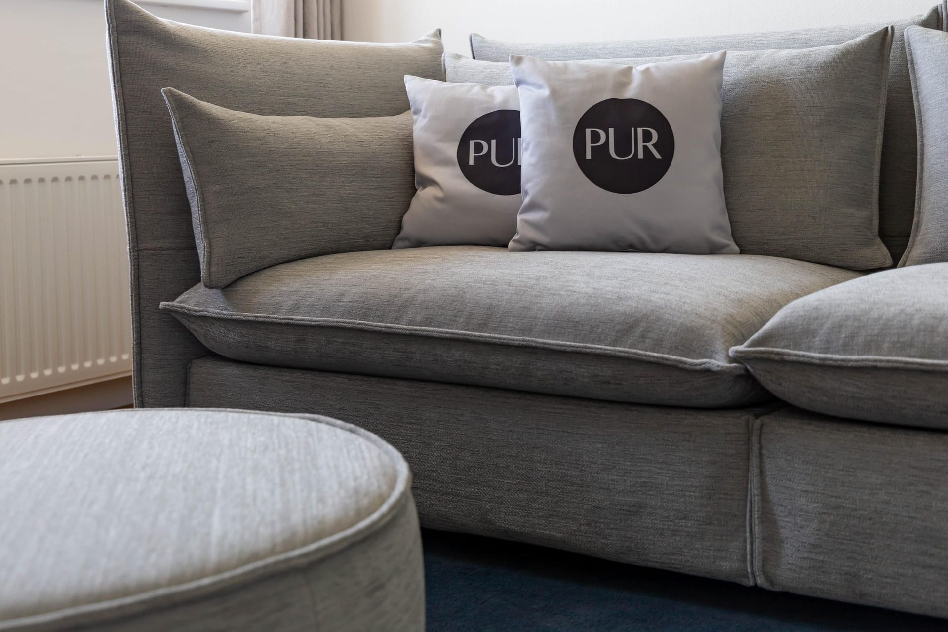 Gemütliches Wohnzimmer mit grauem Sofa und Kissen