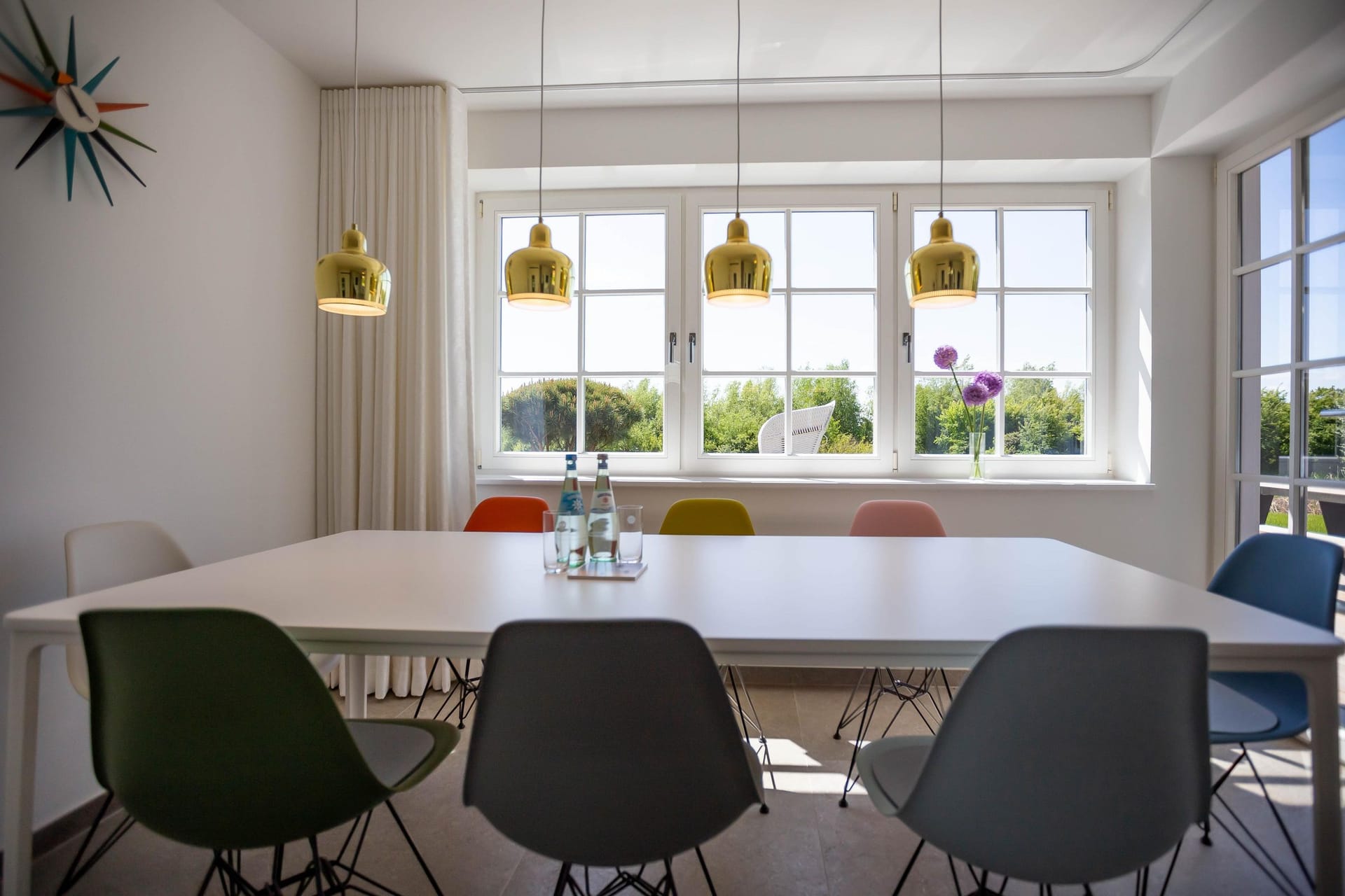 Moderne Küche mit großem Esstisch und bunten Stühlen