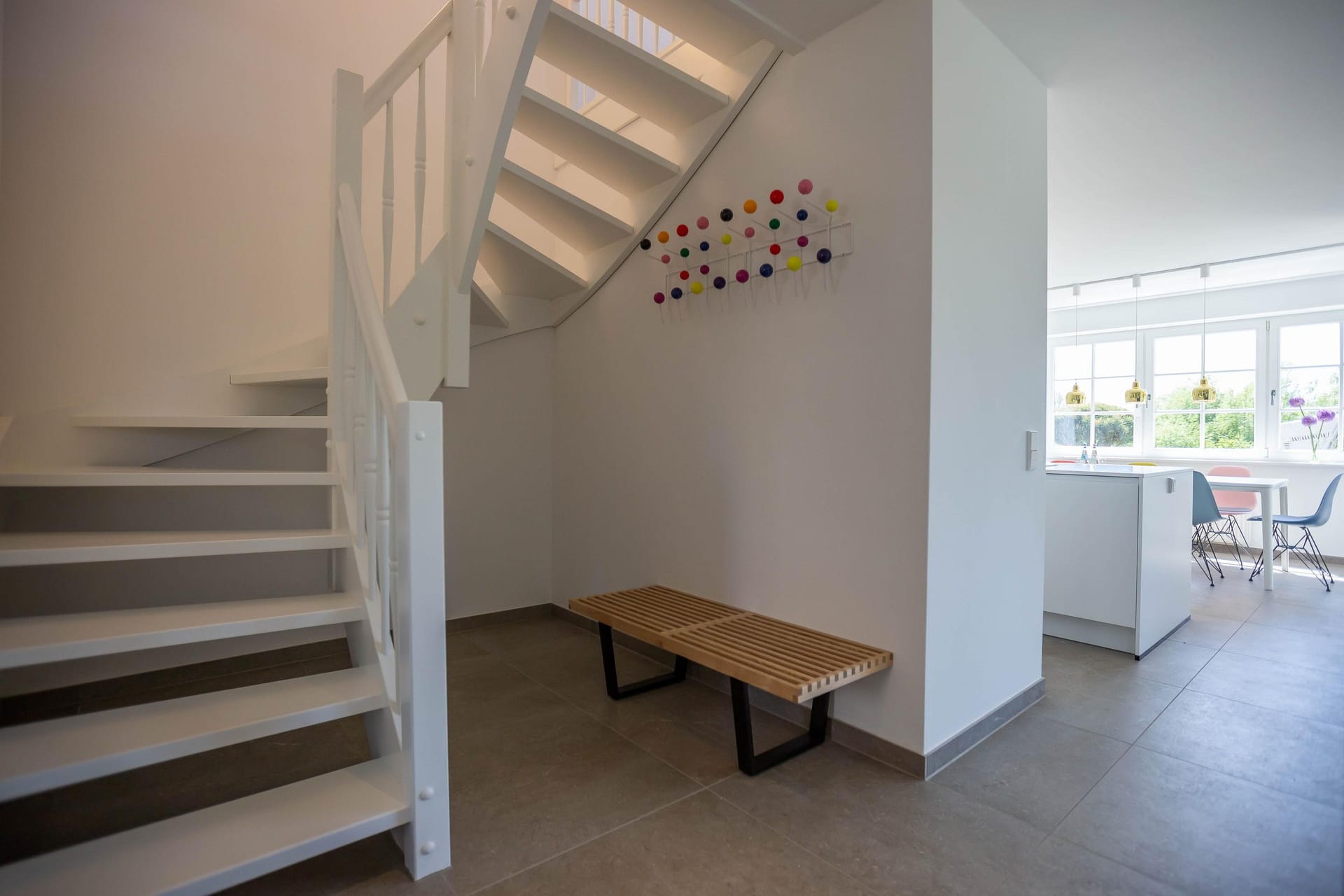 Heller Eingangsbereich mit Treppe und Sitzbank