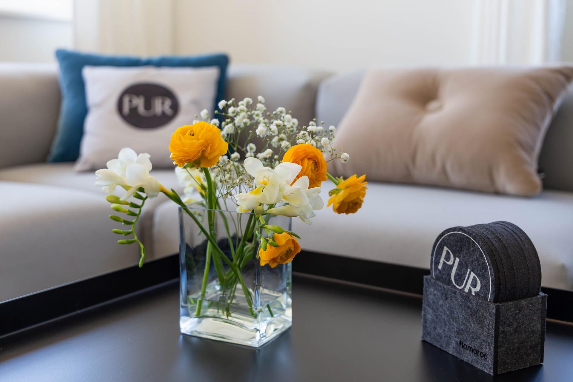 Wohnzimmer mit Sofa und frischem Blumenstrauß