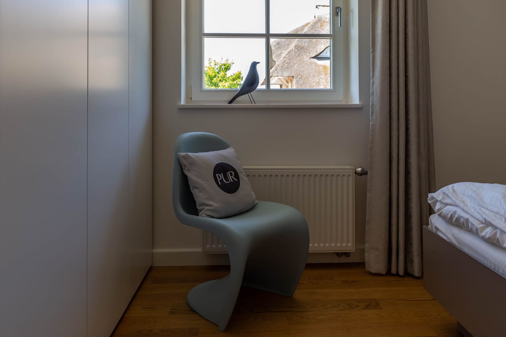 Schlafzimmer mit modernem Stuhl und Fensterblick