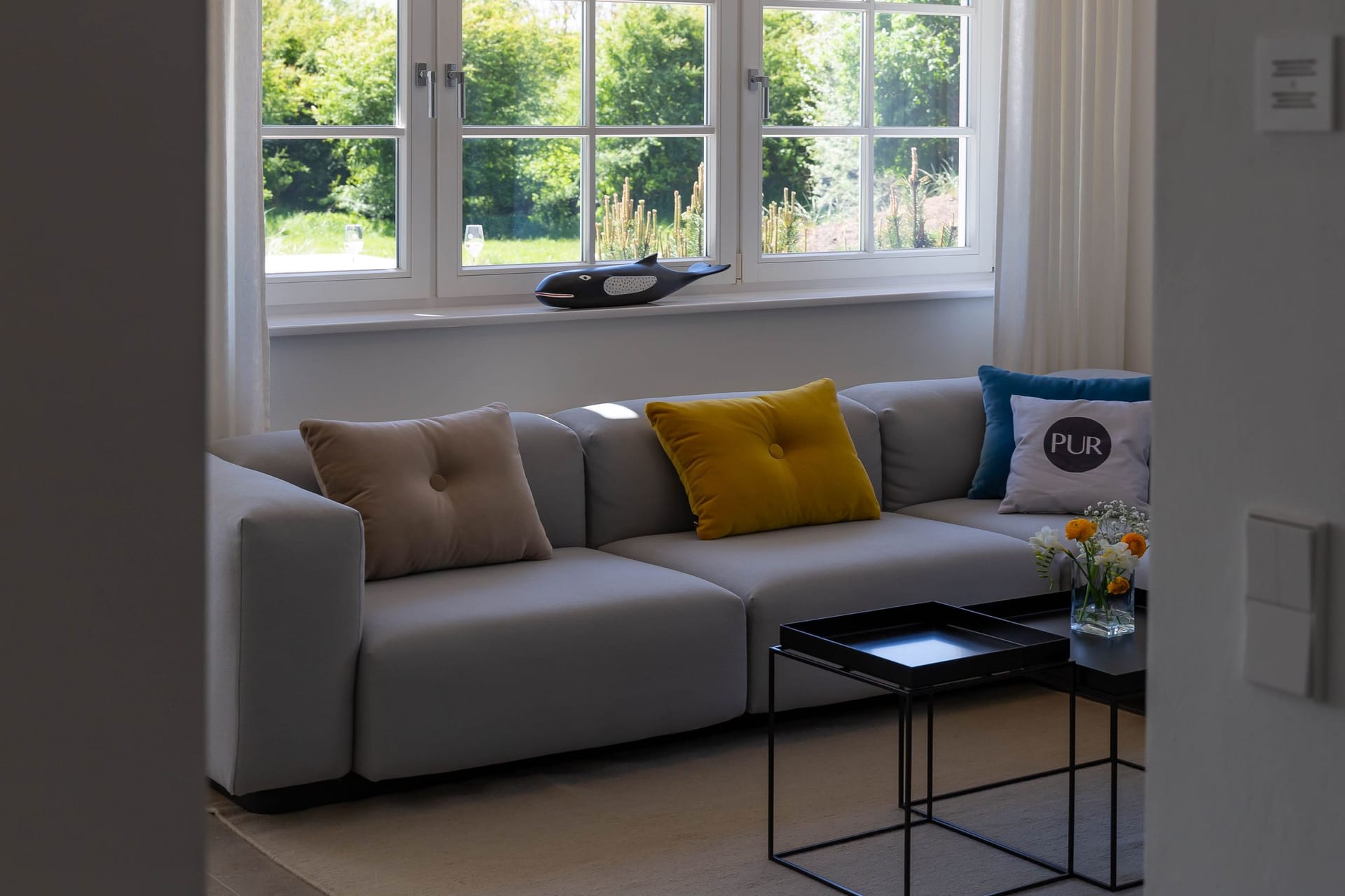 Helles Wohnzimmer mit Sofa und Pflanzenblick.