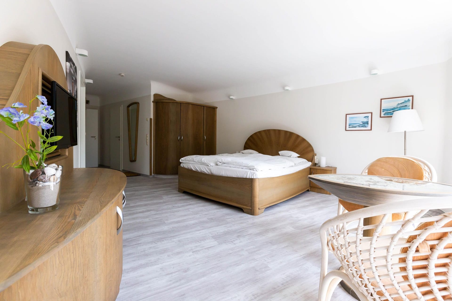Helles Schlafzimmer mit Doppelbett und Holzmöbeln