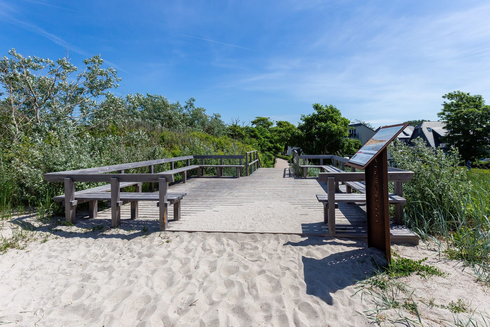 Holzsteg zum Strand umgeben von Vegetation