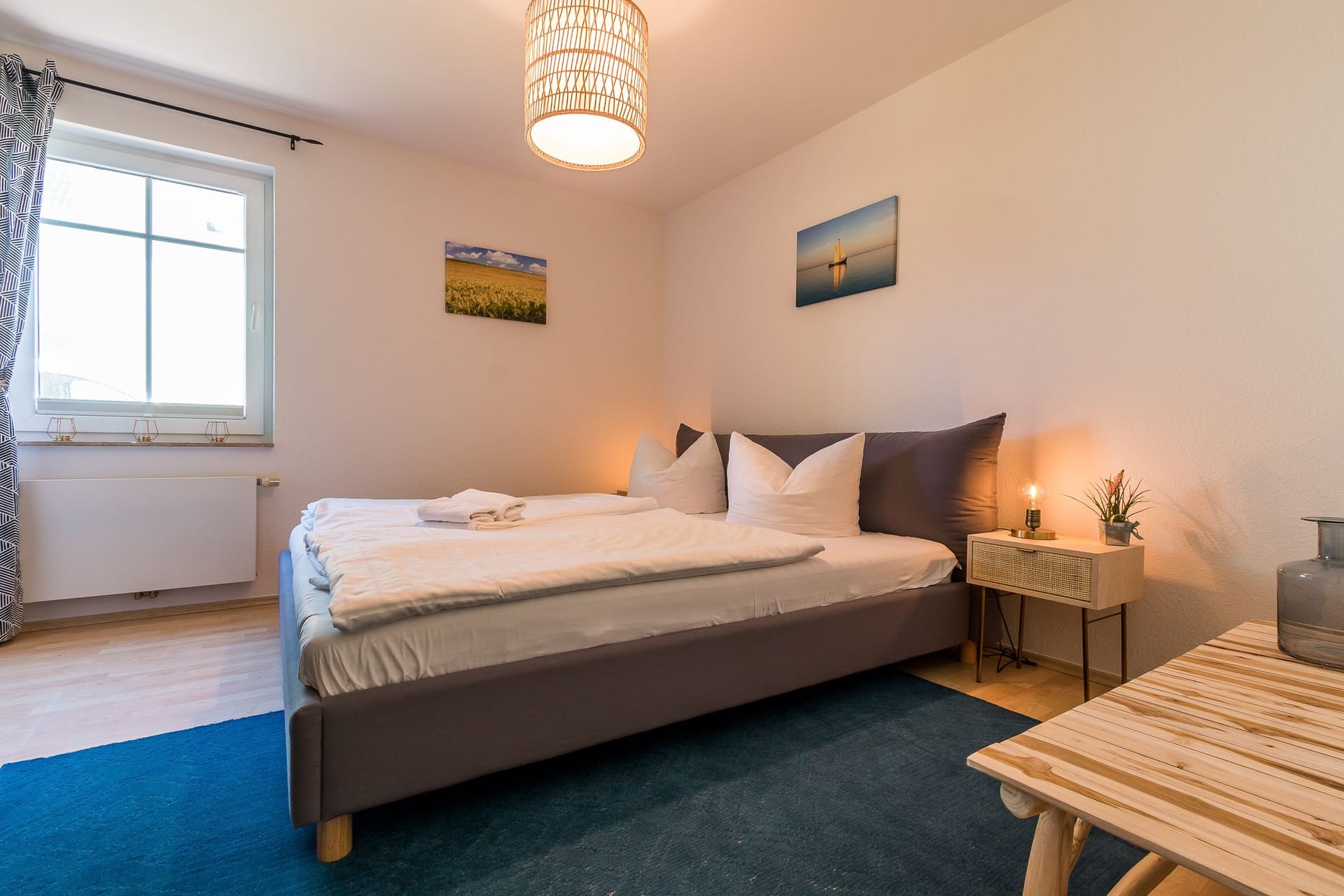 Helles Schlafzimmer mit Doppelbett und Tisch