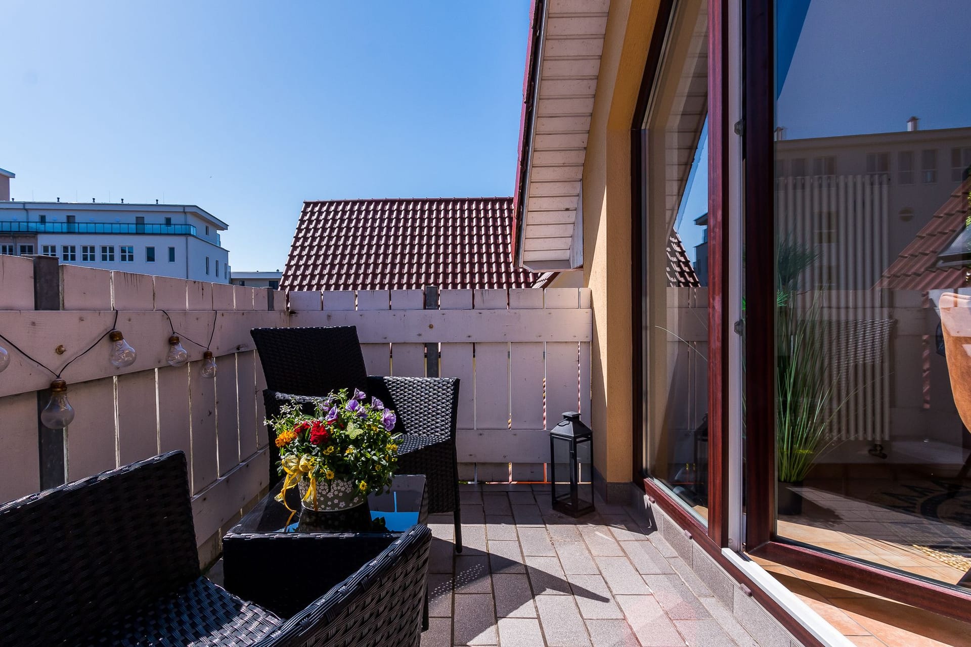 Terrasse mit zwei Stühlen und Blumentopf.