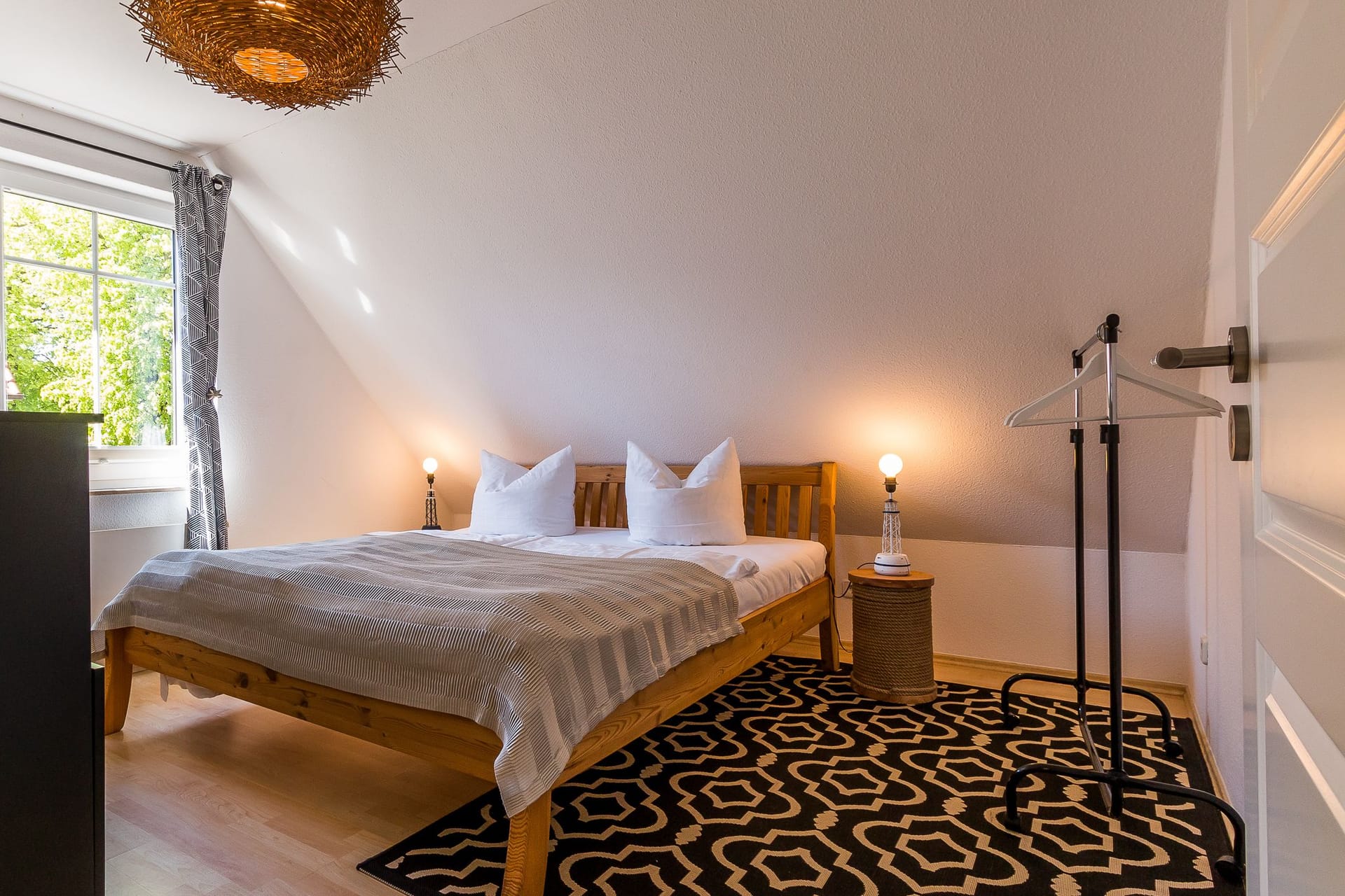 Helles Schlafzimmer mit Holz-Bett und Fenster